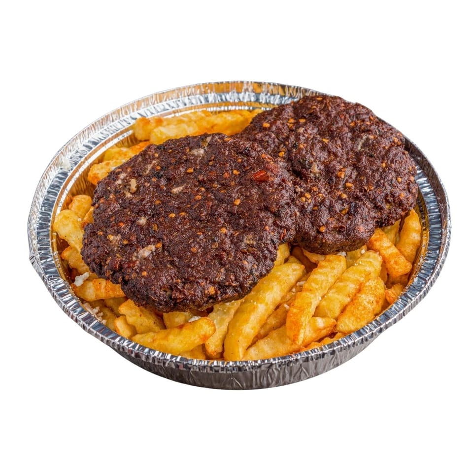 Two spicy dark brown patties on a bed of golden french fries in a foil container.