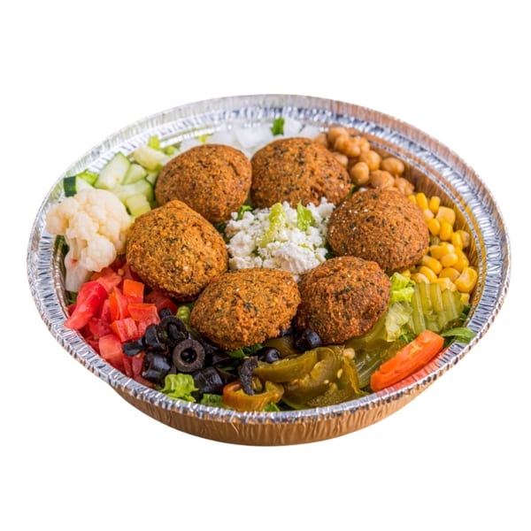 Falafel salad in a foil container with chickpeas, corn, olives, tomatoes, cauliflower, and feta.