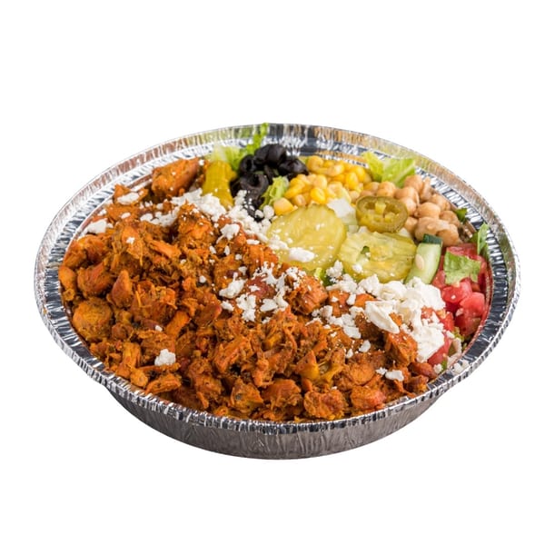 A foil container filled with seasoned chicken, feta, corn, olives, pickles, chickpeas, and salad.